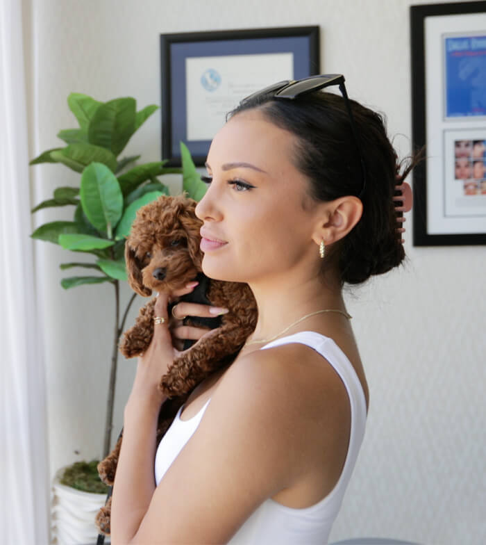 Picture of a female holding a brown dog