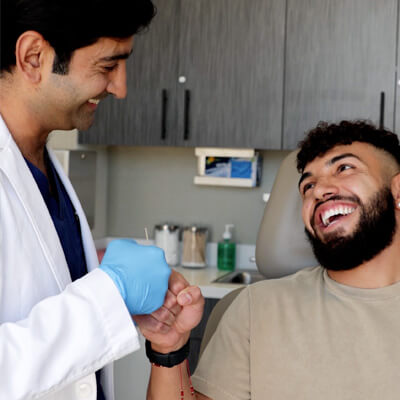 Dr Dhir smiling along with his male patient